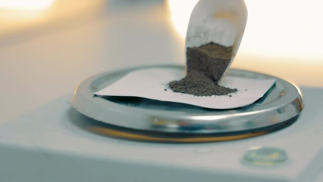 A laboratory technician measures the weight of a sample of the finished product. Weighing soil samples in the laboratory.