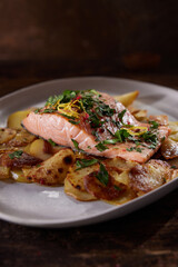 Served salmon steak with potatoes placed on table