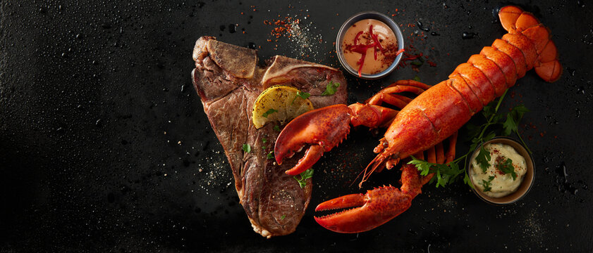 Appetizing lobster and steak with spices and lemon