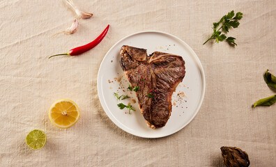 Roasted meat with lemon and pepper on table