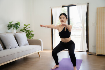 Asian woman takes an online yoga class.