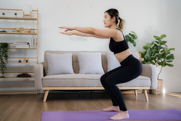 Asian woman takes an online yoga class.