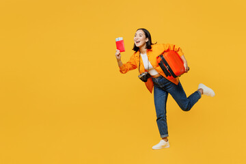 Young woman wear summer clothes hold passport ticket suitcase raise up hand isolated on plain yellow background. Tourist travel abroad in free spare time rest getaway. Air flight trip journey concept