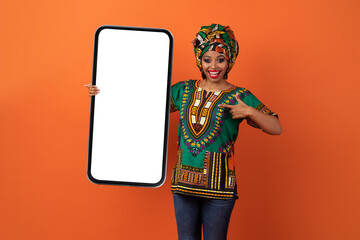 Excited traditional african woman holding huge smartphone, mockup