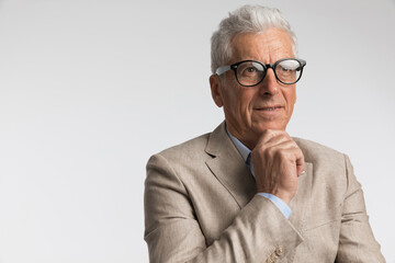 thoughtful man with grey hair wearing glasses and thinking