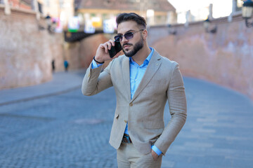 elegant young businessman in suit having a phone conversation