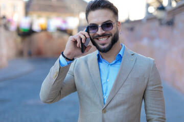 happy businessman in suit talking on the phone and laughing