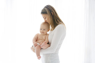 Mother, holding her sick baby boy, sad baby, isolated on white