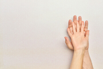 woman's hands over man's hands on bright white background