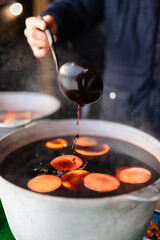 Christmas mulled wine at the fair brewed in a cauldron with cinnamon and citrus. Cooking a traditional Christmas and New Year's drink