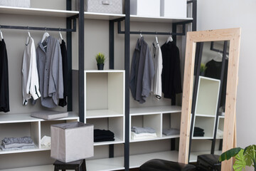 Front view of modern and large wardrobe in dressing room with fashionable woman clothes wear