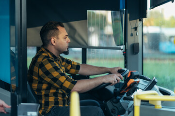 Fototapeta na wymiar Bus driver behind the wheel of a public transport vehicle