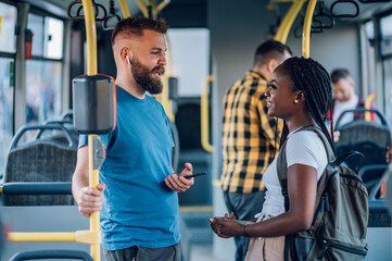Multiracial friends talking while riding a bus in the city - Powered by Adobe