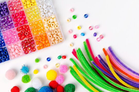 Set for children's crafts. Pipe Cleaners, beads and colorful pom-poms. Different multi-colored supplies and materials for DIY art activity for kids. Motor skills, creativity and  hobby.