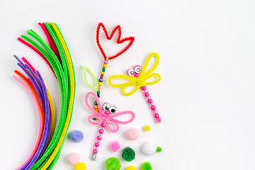 Beaded Pipe Cleaner flowers and dragonflies. Easy spring kids crafts. Different multi-colored supplies and materials for DIY art activity for kids. Children's crafts, creativity and  hobby.