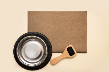 dog bowl and wool brush on beige background with blank blank brown sheet for text, copy space