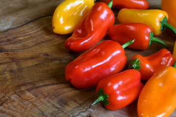 Close up on red and yellow peppers on wooden background