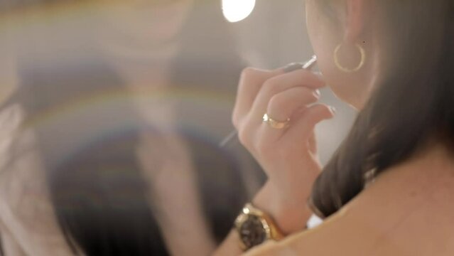 The stylist applies lipstick to the lips of the female model. Woman making make up applying lipstick on a lip. Professional makeup. Tutorial makeup master class