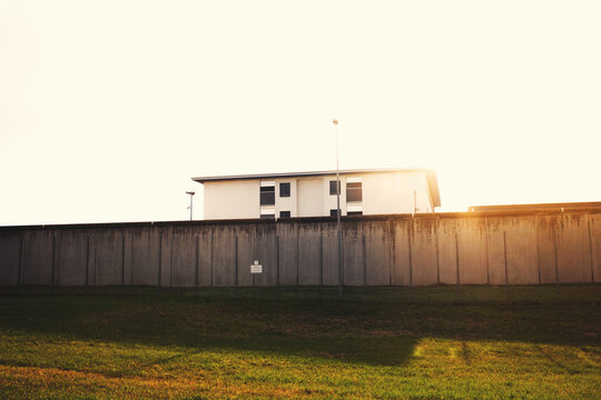 A prison with high concrete walls and barbed wire.