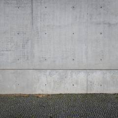 fair faced concrete wall and cobbled sidewalk. Beton brut floor or wall construction material
