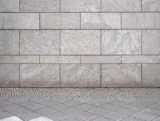 natural stone wall and paved sidewalk as background. Close-up of a wall clad in limestone