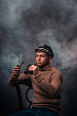 Vessel captain. A man in a sweater and cap. Smokes a pipe. Male profession.