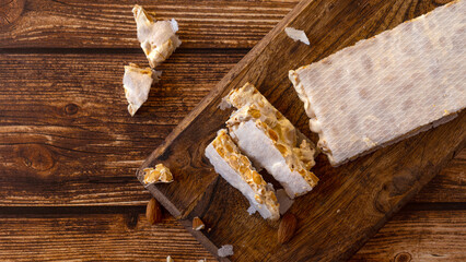 Top view of Almond Spanish turron dessert slices with nuts on on wooden desk