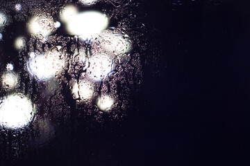 Bokeh lights through a wet window.