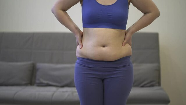 Abdominal massage, tummy tuck and flabby skin on a fat belly, woman doing self-massage, plastic surgery concept