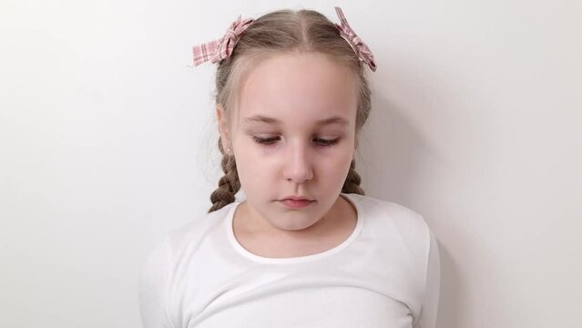 Sad stressed little girl expressing negative emotions, sorrow, bad mood. Female kid isolated on white background