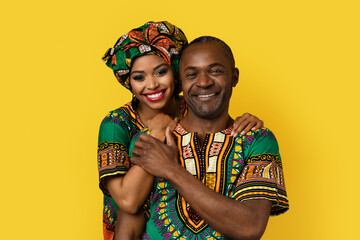 Fototapeta na wymiar Portrait of lovely black couple in national costumes on yellow