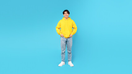 Full Length Shot Of Happy Asian Teen Over Blue Background