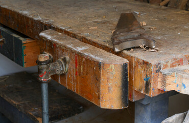 vise in the workbench of an artisan carpentry and a saw with a toothed blade