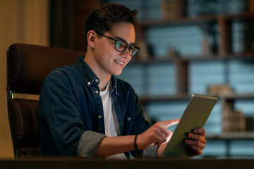 Smiling young man holding using digital tablet pc at office