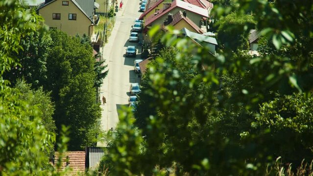 Rowerzyści jadący małym miasteczkiem widziani z oddali. Ciepłe lato powietrze drga 
