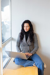 Beautiful businesswoman working on a laptop. Female freelancer connecting to internet via computer. Blogger or journalist writing new article.