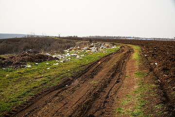 Obraz premium Pollution of the environment with garbage. Plastic garbage, household garbage thrown on the field.