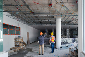 Engineer or Architect discussing with contractor about project in building construction site.g...