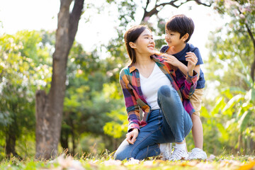 Asian woman and boy playing and walking around the park together with beautiful bokeh and lighting...