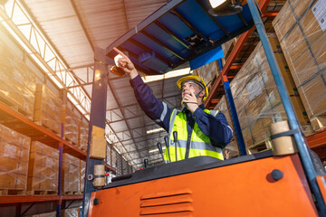 Fototapeta na wymiar Russian European male staff worker working control loading operate forklift in warehouse inventory factory