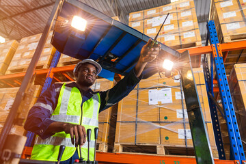 Fototapeta na wymiar African black male staff worker working control loading operate folk lift in warehouse inventory factory