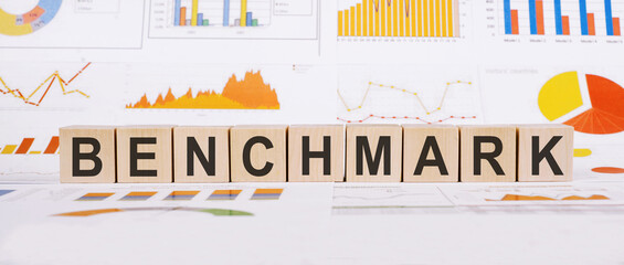Benchmark word on wooden cubes on financial background