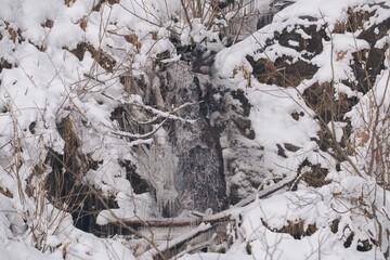 a small mountain creek with icicles at a cold winter day