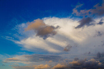 Naklejka na ściany i meble cloud against thunderstorm sky at sunset, illuminated by the sun's rays