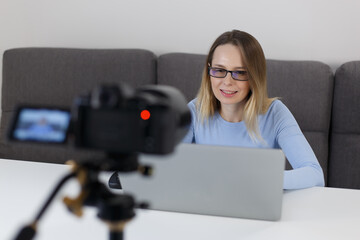 Teacher filming educational video course at home. Portrait of friendly white woman speaking on...
