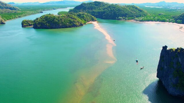 The shallow waters surrounding the sandbar are often calm and clear, making them ideal for swimming, snorkeling, or other water-based activities. (Dragon Spine Beach, Satun Province, Thailand). 4K Dro