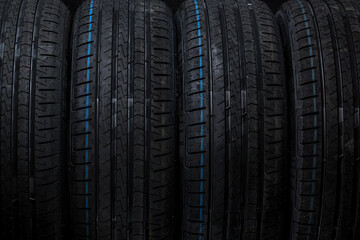 Stack of brand new high performance car tires on clean high-key white studio background