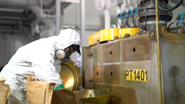 A worker in white uniform is working in a factory