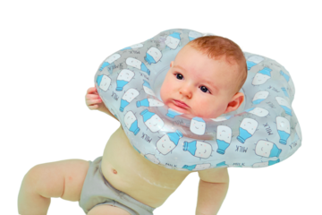 Infant swimming, a boy swims in a home bath with an inflatable ring on his neck, isolated on a white background. Kid aged four months