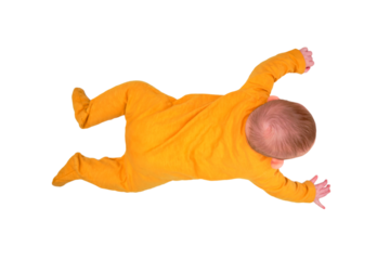 Infant baby lies on the play mat and reaches for a piggy bank, top view, isolated on a white background. Toddler on the white floor full length, copy space. Kid aged six months